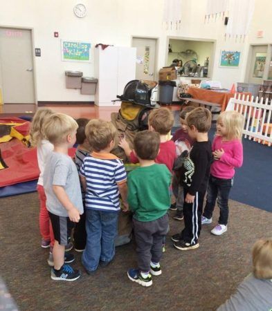 preschoolers_looking_at_fireman_gear_carolina_kids_child_development_center_fort_mill_sc-393x450
