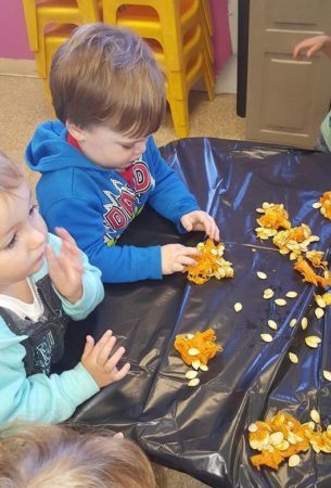 preschoolers_playing_with_pumpkin_seeds_prime_time_early_learning_centers_middletown_ny-305x450