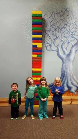 preschoolers_standing_in_front_of_huge_stack_of_blocks_cadence_academy_preschool_milwaukie_portland_or-253x450