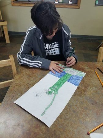 school_age_boy_drawing_the_statue_of_liberty_cadence_academy_preschool_san_antonio_tx-336x450