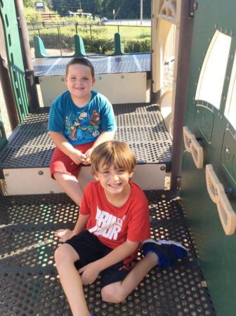 school_age_boys_sitting_on_playground_equipment_sunbrook_academy_at_woodstock_ga-336x450