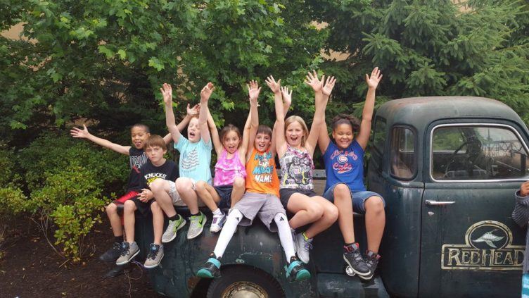 school_agers_on_back_of_stepside_truck_during_field_trip_rogys_learning_place_pekin_il-752x423