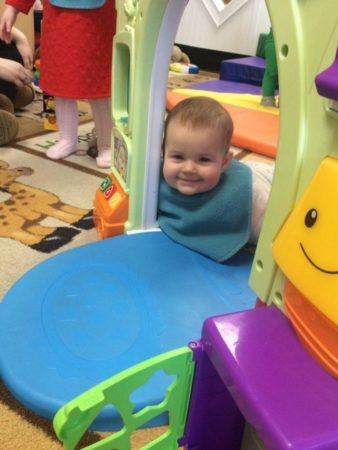 silly_toddler_smiling_at_play_door_cadence_academy_preschool_east_greenwich_ri-338x450