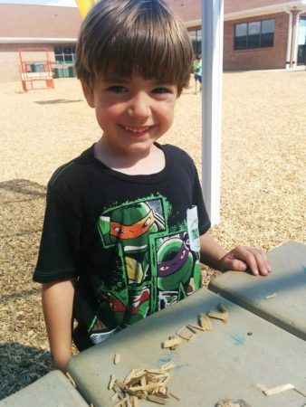 smiling_preschool_boy_on_playground_at_cadence_academy_preschool_surfside_myrtle_beach_sc-338x450