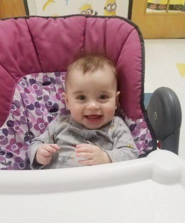 smiling_toddler_in_high_chair_prime_time_early_learning_centers_farmingdale_ny-374x450