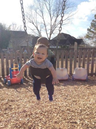 smiling_toddler_in_swing_at_cadence_academy_preschool_summerville_sc-333x450