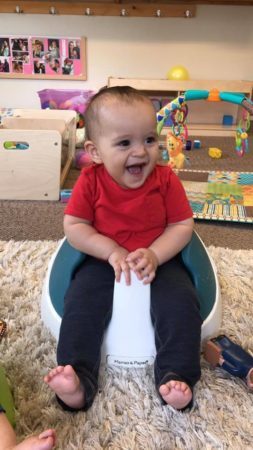 smiling_toddler_sitting_in_mamas_and_papas_seat_cadence_academy_preschool_tualatin_or-253x450