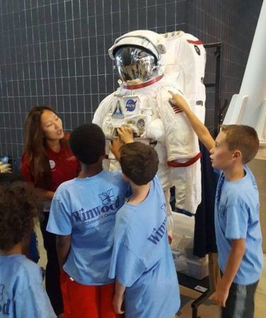 summer_campers_looking_at_space_suit_winwood_childrens_center_brambleton_ii_va-376x450