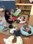 teacher_and_toddlers_sitting_together_on_floor_winwood_childrens_center_ashburn_va-338x450