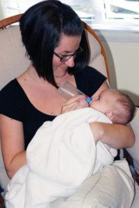 teacher_feeding_infant_cadence_academy_preschool_fayetteville_ar-300x450