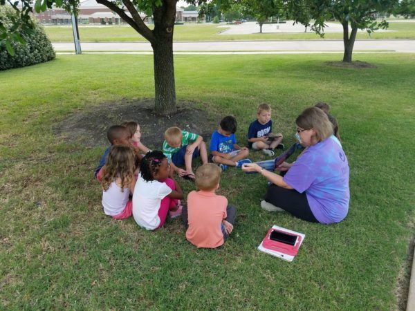 teacher_reading_a_book_outside-600x450