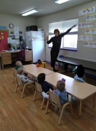 teacher_showing_2-year-olds_how_to_count_miss_muffets_learning_center_klamath_falls_or-330x450
