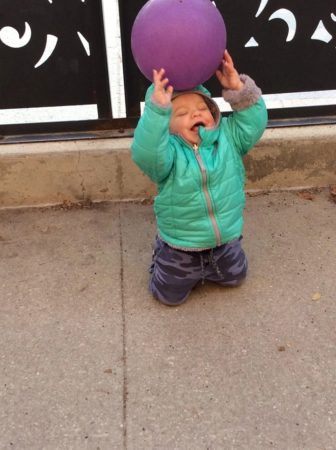 toddler_balancing_a_ball_on_head_cadence_academy_preschool_iowa_city_ia-336x450