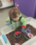 toddler_digging_through_dirt_rogys_learning_place_hilltop_peoria_il-358x450