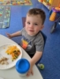 toddler_enjoying_lunch_creative_kids_childcare_centers_beekman-338x450