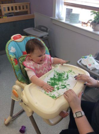 toddler_fingerpainting_in_high_chair_at_next_generation_childrens_centers_walpole_ma-333x450
