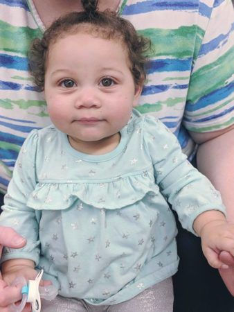 toddler_girLsitting_on_teachers_lap_rogys_learning_place_hilltop_peoria_il-338x450