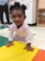 toddler_girl_crawling_on_colorful_mat_winwood_childrens_center_gainesville_ii_va-336x450