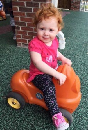 toddler_girl_on_scotter_at_cadence_academy_eastfield_huntersville_nc-303x450