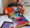 toddler_girl_reading_book_on_elmo_lounger_prime_time_early_learning_centers_east_rutherford_nj-490x450
