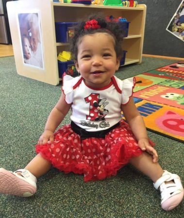 toddler_girl_smiling_while_sitting_sunbrook_academy_at_barnes_mill_austell_ga-379x450