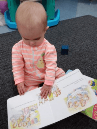 toddler_looking_through_book_jonis_child_care_preschool_farmington_ct-338x450