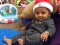 toddler_lounging_in_santa_hat_cadence_academy_preschool_steele_creek_charlotte_nc-1024x765-602x450