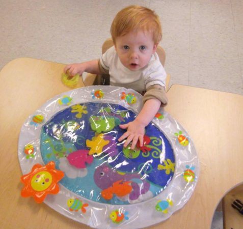 toddler_playing_with_fish_toy_cadence_academy_preschool_urbandale_ia-477x450