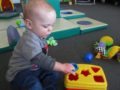 toddler_playing_with_shape_toy_adventures_in_learning_oswego_il-600x450