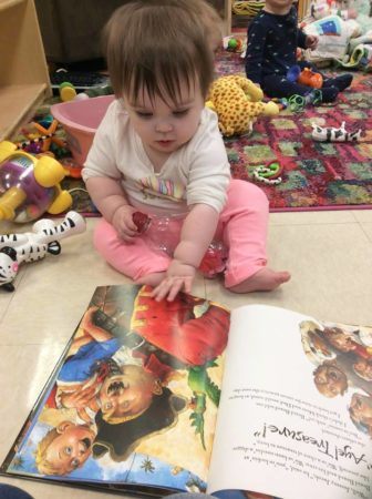toddler_reading_pirate_book_cadence_academy_preschool_iowa_city_ia-336x450