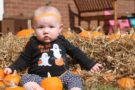 toddler_sitting_in_pumpkin_patch_winwood_childrens_center_lansdowne_va-676x450