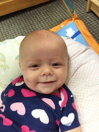 toddler_smiling_while_lounging_sunbrook_academy_at_luella_mcdonough_ga-338x450