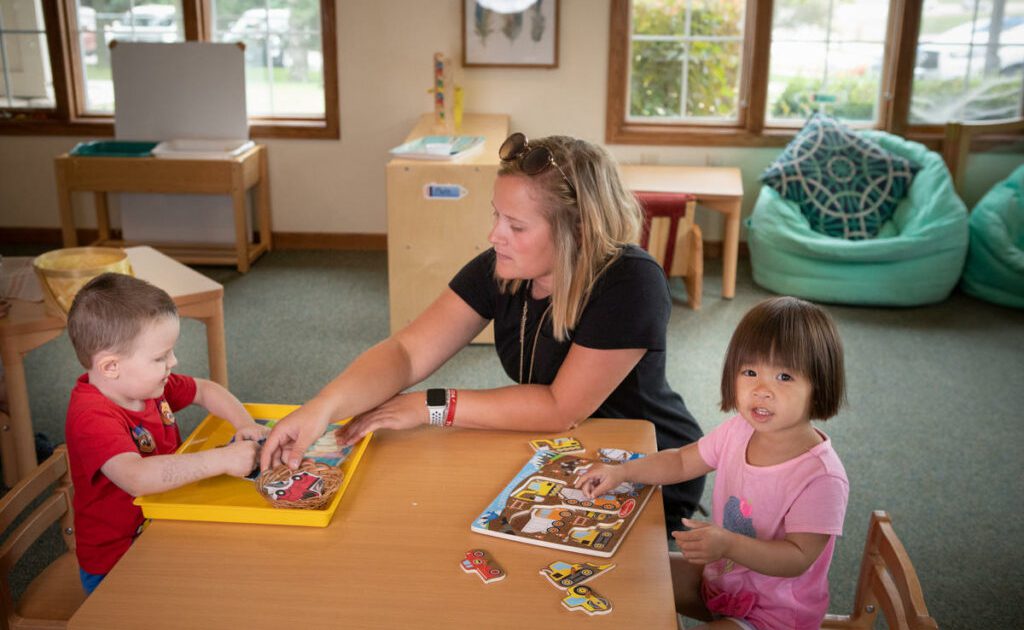A teacher guiding children indoors