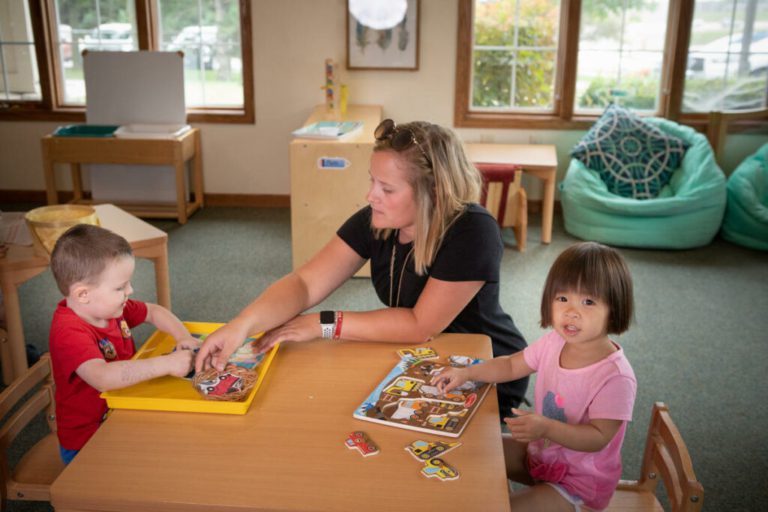 A teacher guiding children indoors