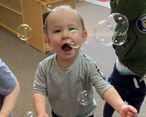 baby playing with bubbles at cadence academy preschool draper
