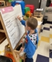 child writing on whiteboard