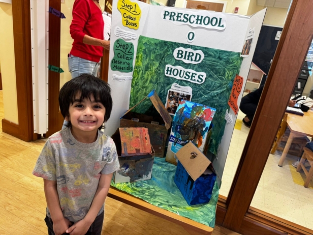 Child smiling with project at preschool and daycare at cadence academy preschool 452 south street