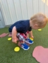 boy picking up objects in a path on the ground