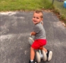 child riding bike looking backwards at person taking the picture