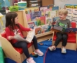 children reading in reading corner sitting in little chairs