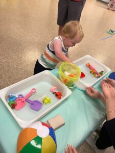 child playing with summer toys in water bin at cadence academy preschool 453 pond