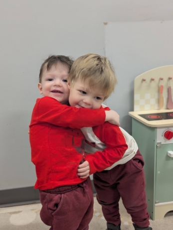 children hugging each other at cadence academy preschool 454 eliot