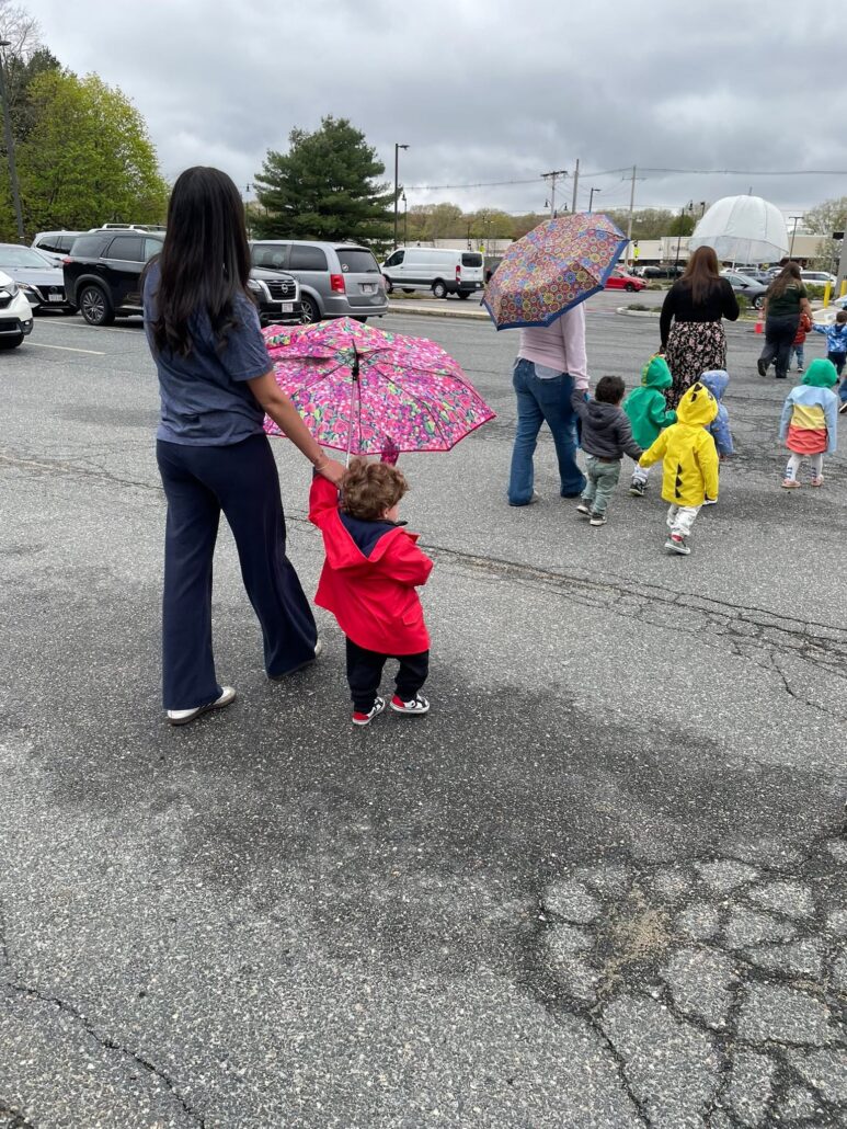 children holding hands with teachers as they walk outside at cadence academy preschool 453 pond