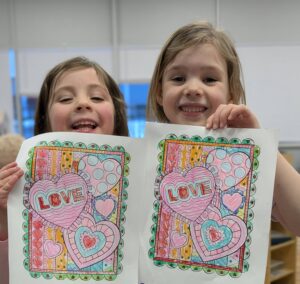 children holding up the pictures they have colored in at cadence academy preschool 454 eliot