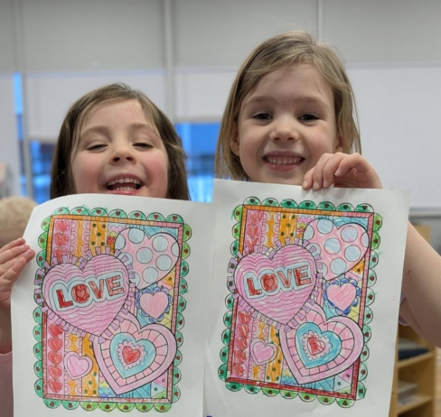 children holding up the pictures they have colored in at cadence academy preschool 454 eliot