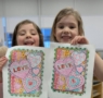 children holding up the pictures they have colored in at cadence academy preschool 454 eliot