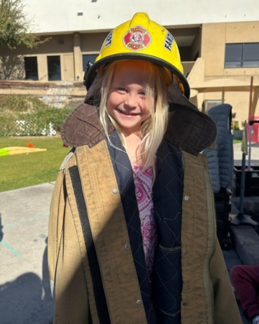 female child wearing firefighter's gear at little big minds uptown