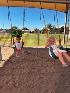 female children playing outside on swings at little big minds uptown