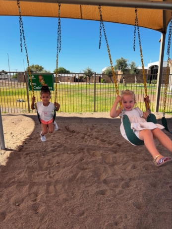 female children playing outside on swings at little big minds uptown