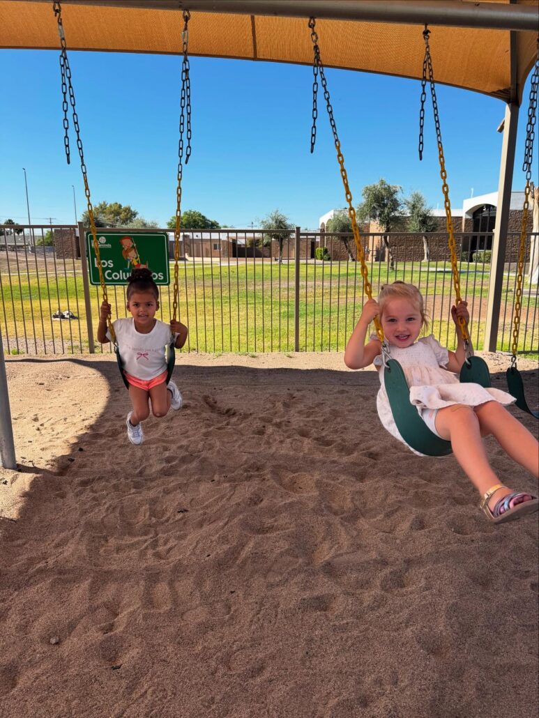 female children playing outside on swings at little big minds uptown